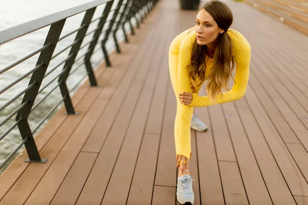 Söt Ung Kvinna Som Stretchar Piren Vid Floden — Stockfoto