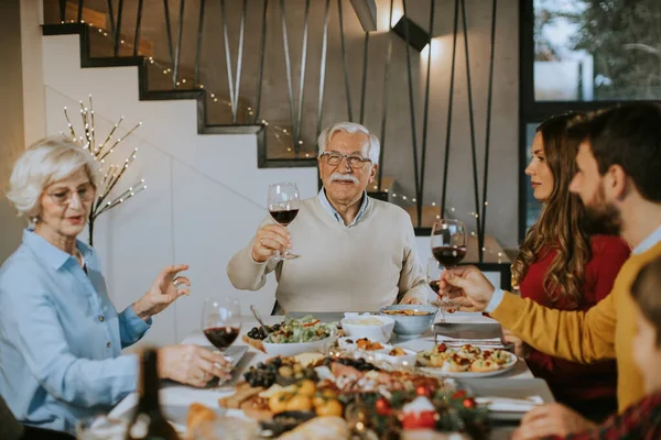 幸せな家族は家で赤ワインと夕食を持っています — ストック写真