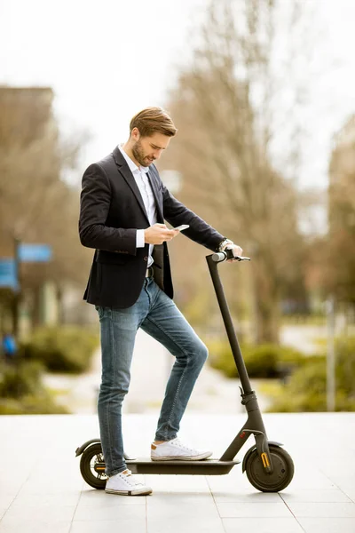 Knappe Jonge Zakenman Met Behulp Van Mobiele Telefoon Elektrische Scooter — Stockfoto