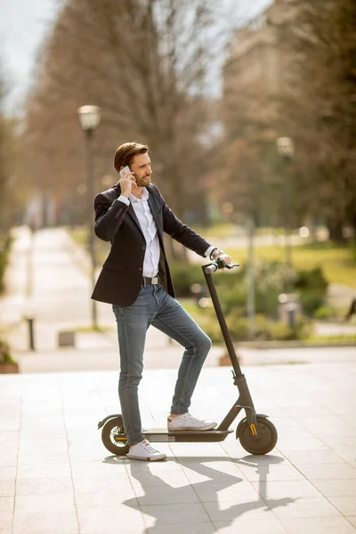 Knappe Jonge Zakenman Met Behulp Van Mobiele Telefoon Elektrische Scooter — Stockfoto