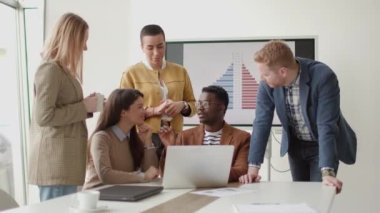 Çok ırklı genç iş adamlarından oluşan bir grup birlikte çalışıyor ve ofiste yeni bir proje hazırlıyorlar.