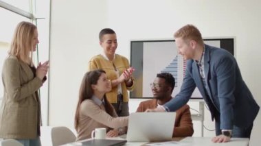 Çok ırklı genç iş adamlarından oluşan bir grup birlikte çalışıyor ve ofiste yeni bir proje hazırlıyorlar.