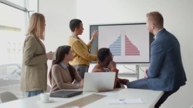 Çok ırklı genç iş adamlarından oluşan bir grup birlikte çalışıyor ve ofiste yeni bir proje hazırlıyorlar.