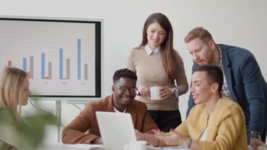 Çok ırklı genç iş adamlarından oluşan bir grup birlikte çalışıyor ve ofiste yeni bir proje hazırlıyorlar.