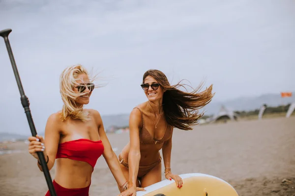 Δύο Όμορφες Νεαρές Γυναίκες Σανίδα Στην Παραλία Μια Καλοκαιρινή Μέρα — Φωτογραφία Αρχείου