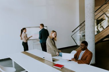 Çok ırklı genç iş adamlarından oluşan bir grup birlikte çalışıyor ve ofiste yeni bir proje hazırlıyorlar.