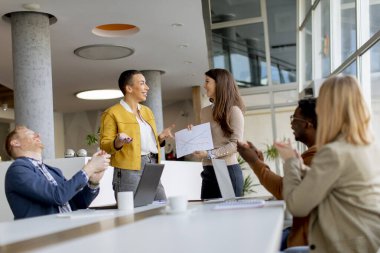 Çok ırklı genç iş adamlarından oluşan bir grup birlikte çalışıyor ve ofiste yeni bir proje hazırlıyorlar.