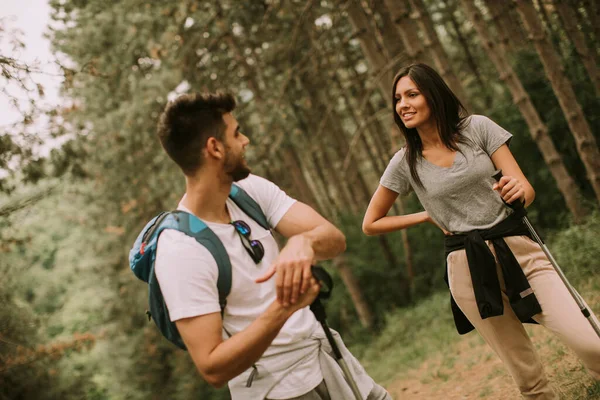 两个背着背包的年轻徒步旅行者穿过森林 — 图库照片