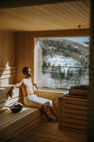 Hezký Mladý Muž Odpočívající Sauně Pozorující Zimní Les Oknem — Stock fotografie
