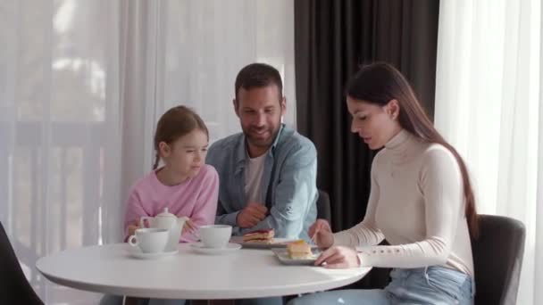 Glückliche Junge Familie Isst Gemeinsam Kuchen Und Trinkt Tee Auf — Stockvideo