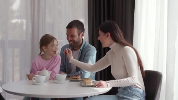 Счастливая Молодая Семья Ест Пирожные Пить Чай Вместе Комнате — стоковое видео