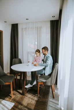 Baba ve kızı oturma odasında çay içiyorlar.