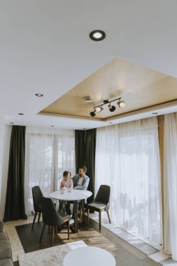 Baba ve kızı oturma odasında çay içiyorlar.