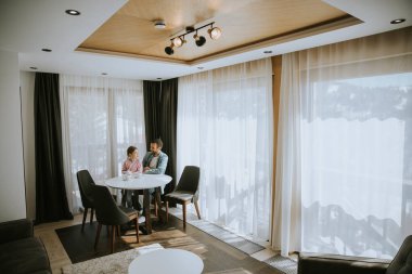 Baba ve kızı oturma odasında çay içiyorlar.