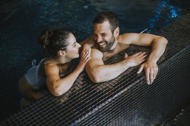 Kapalı bir yüzme havuzunda dinlenen yakışıklı.