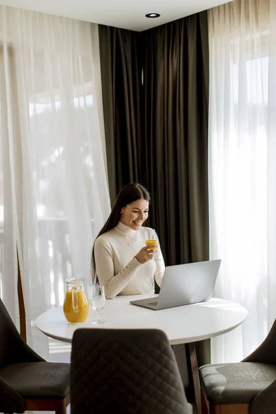 Giovane Donna Che Utilizza Computer Portatile Bere Succo Arancia Sano — Foto Stock