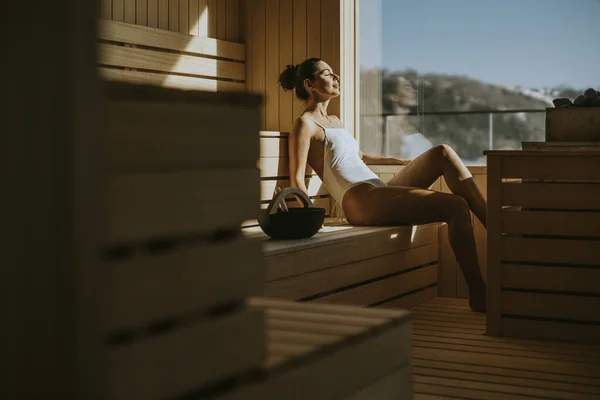 Attractive young woman relaxing in the sauna