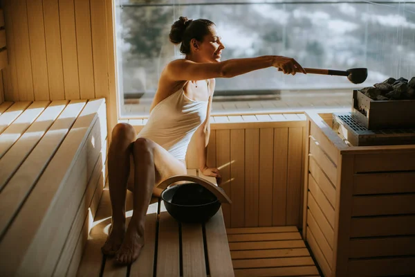 Attraktive Junge Frau Gießt Der Sauna Wasser Auf Heißen Stein — Stockfoto