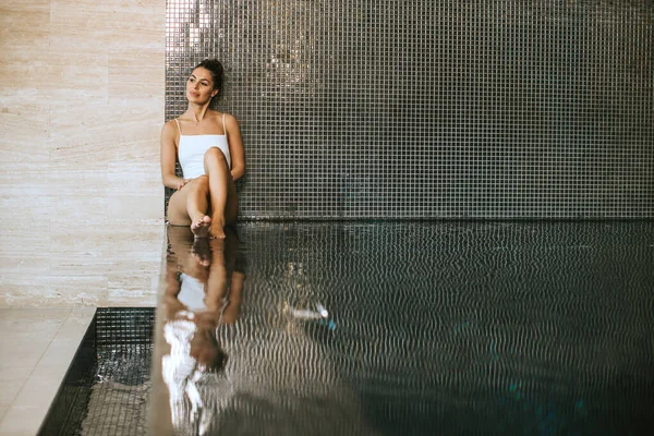 Kapalı Yüzme Havuzunun Havuz Kenarında Dinlenen Güzel Genç Bir Kadın — Stok fotoğraf