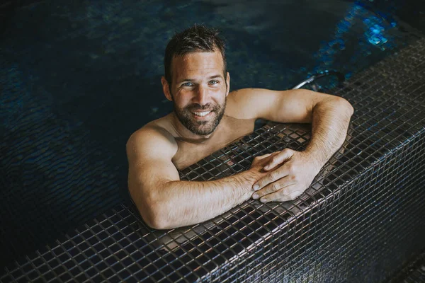 Portrét Pohledného Usmívajícího Mladíka Relaxujícího Okraje Bazénu — Stock fotografie