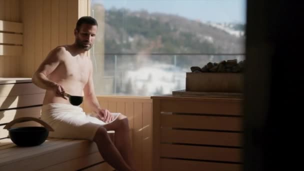 Yakışıklı Genç Adam Saunadaki Sıcak Taşın Üzerine Döküyor — Stok video