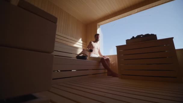 Guapo Joven Vertiendo Agua Sobre Piedra Caliente Sauna — Vídeos de Stock