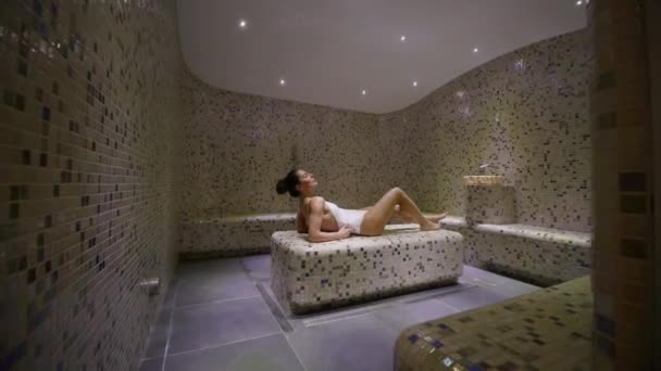 漂亮的年轻女子在温泉浴池的茶馆床上休息 — 图库视频影像