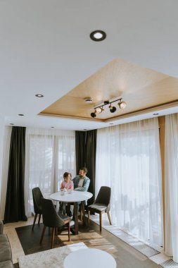 Baba ve kızı oturma odasında çay içiyorlar.