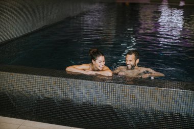 Kapalı bir yüzme havuzunda dinlenen yakışıklı.