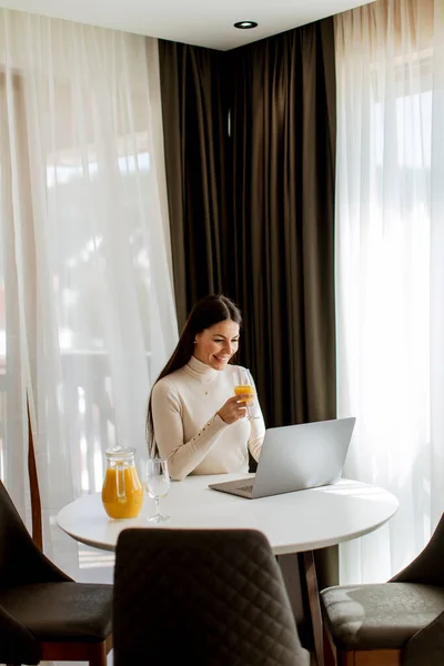 Giovane Donna Che Utilizza Computer Portatile Bere Succo Arancia Sano — Foto Stock