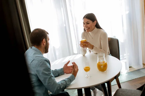 客厅里的一对年轻夫妇喝橙汁 — 图库照片
