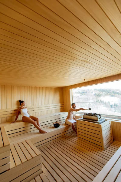 Bonito Casal Jovem Relaxando Sauna Assistindo Floresta Inverno Através Janela — Fotografia de Stock