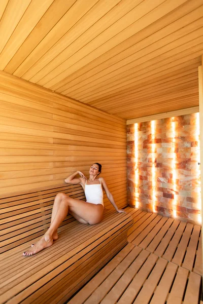 Attractive young woman relaxing in the sauna