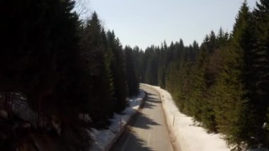 Bir yolu olan karlı dağ ormanının havadan görünüşü