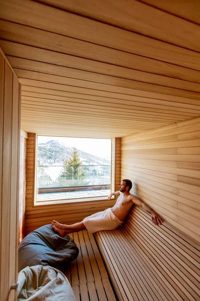 Joven Guapo Relajándose Sauna Viendo Bosque Invierno Través Ventana — Foto de Stock