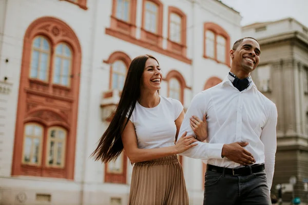 Sokakta yürüyen yakışıklı, etnik çeşitlilikte genç bir çift.