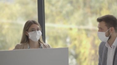 İş adamlarının bir toplantısı var ve ofiste çalışıyorlar. Koronavirüsten korunmak için maske takıyorlar.