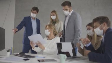 İş adamlarının bir toplantısı var ve ofiste çalışıyorlar. Korona virüsünden korunmak için maske takıyorlar.