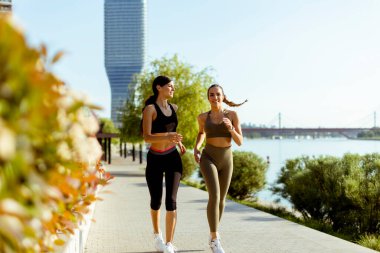 Güzel genç bayan nehir kenarında koşuya çıkıyor.