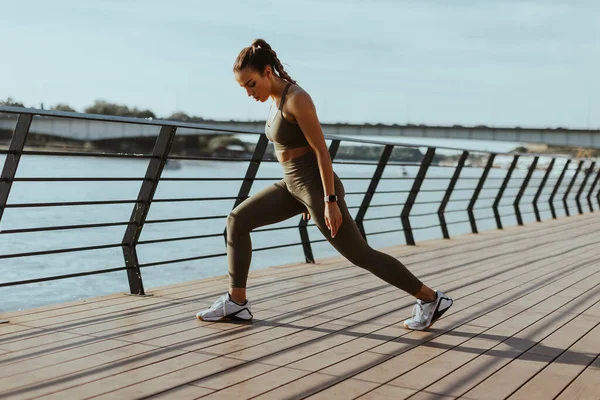 Spor Giyimli Güzel Bir Kadın Nehir Kenarında Egzersiz Yapıyor — Stok fotoğraf