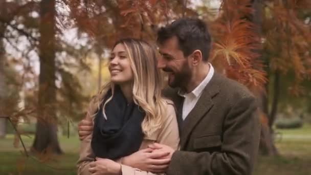 秋の公園を歩いている若い夫婦は — ストック動画