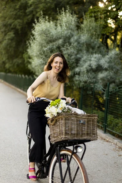 Elektrikli Bisiklet Sepetinde Çiçekli Neşeli Bir Kadın — Stok fotoğraf