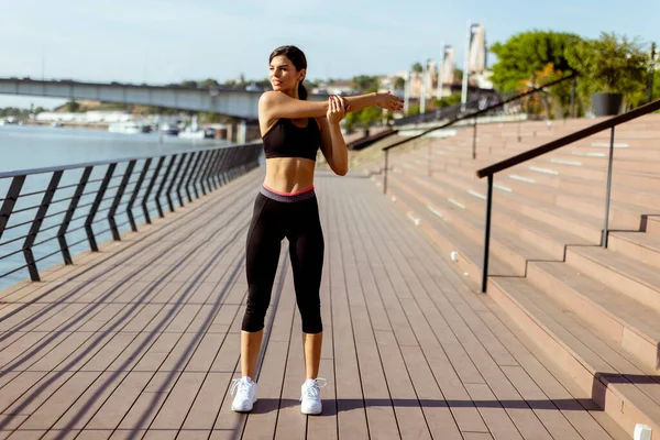 Spor Giyimli Güzel Bir Kadın Nehir Kenarında Egzersiz Yapıyor — Stok fotoğraf