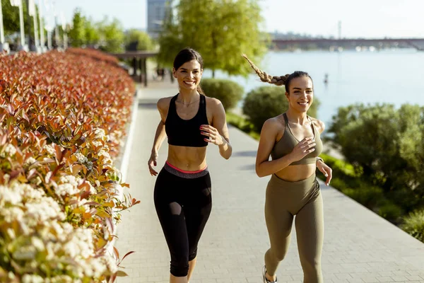 Güzel genç bayan nehir kenarında koşuya çıkıyor.