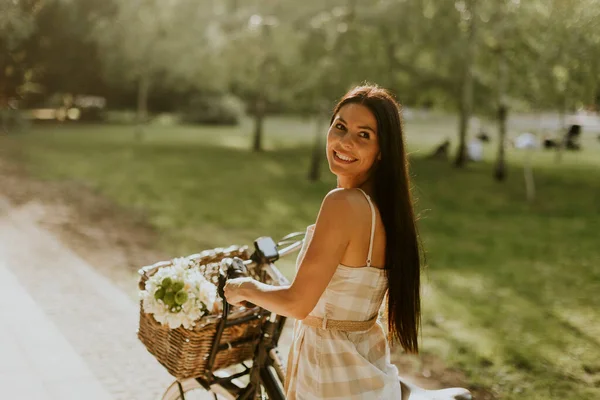 Elektrikli Bisiklet Sepetinde Çiçekleri Olan Güzel Genç Bir Kadın — Stok fotoğraf