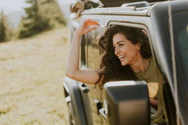 Pretty young woman enjoying freedom in terrain vehicle on a sunny day