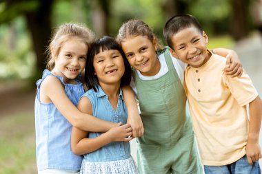 Group of cute asian and caucasian kids having fun in the park