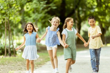 Group of cute asian and caucasian kids having fun in the park