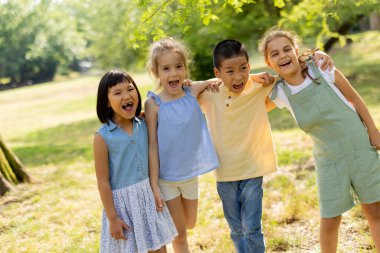 Group of cute asian and caucasian kids having fun in the park