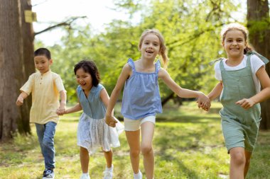 Group of cute asian and caucasian kids having fun in the park